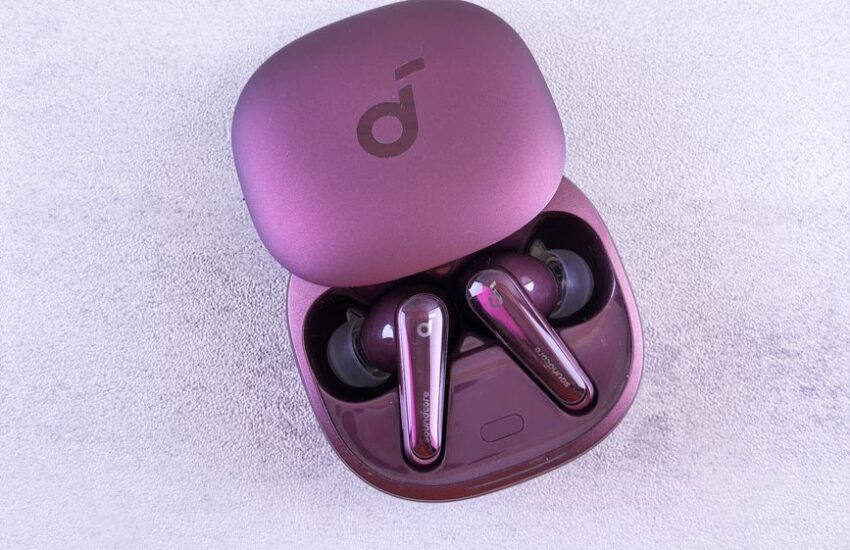 Een persoon die geniet van muziek met noise cancelling oordopjes in een drukke trein, omringd door storende geluiden.
